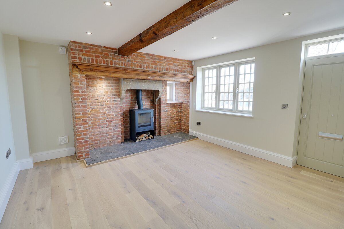 Restored brick fireplace and exposed beam in the Bare Hills View lounge