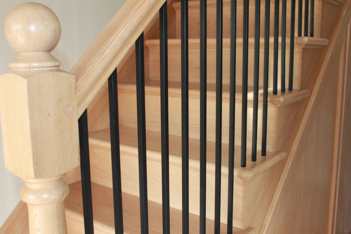 Oak staircase joinery with dark metal spindles